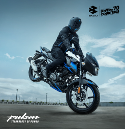 A motorcyclist performs a wheelie on a sleek Bajaj Pulsar 150 bike, set against a backdrop of a cloudy sky.