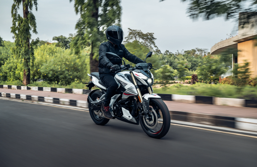 Pulsar N160  bike in blue parked against a modern backdrop, with a helmeted rider in the foreground